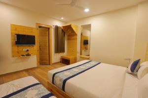 a hotel room with two beds and a television at The Grand Uddhav- a boutique hotel in Udaipur