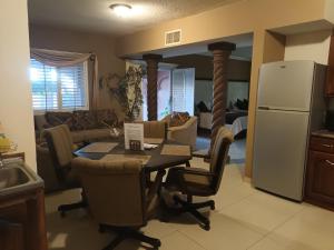 cocina y sala de estar con mesa y nevera en Confortable y acogedor Departamento por UACH II, en Chihuahua