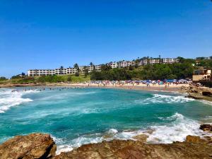a beach with people in the water and buildings at Du Bantry 14 in Uvongo Beach