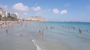 un grupo de personas en el agua en una playa en Mar y Sol Suites, en Grao de Castellón