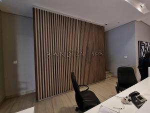 a conference room with two desks and chairs and a partition at Sandton Skye - luxury apartment in Johannesburg +3 photos