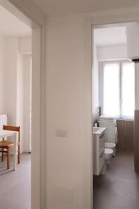 Baño blanco con aseo y lavamanos en Appartamento Lorenteggio - Piazza Frattini affaccio interno, 2 balconi, en Milán