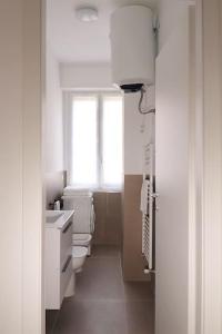 baño con 2 aseos, lavamanos y ventana en Appartamento Lorenteggio - Piazza Frattini affaccio interno, 2 balconi, en Milán