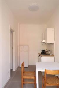 cocina con mesa y 2 sillas en Appartamento Lorenteggio - Piazza Frattini affaccio interno, 2 balconi, en Milán