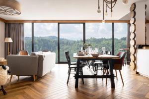ein Esszimmer und ein Wohnzimmer mit Tisch und Stühlen in der Unterkunft Czorsztyn Prestige Apartamenty in Czorsztyn