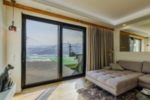 a living room with a couch and a large window at MountainBase - Widokowy 1 in Kościelisko