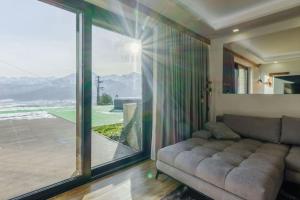a living room with a couch and a large window at MountainBase - Widokowy 1 in Kościelisko