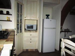 cocina con nevera blanca y microondas en Apartment in the heart of Tuscany, en Montelupo Fiorentino
