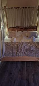 un grand lit avec un cadre en bois dans une chambre dans l'établissement Agriturismo La Pina, à Tarzo