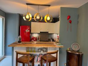 a kitchen with a counter and a red refrigerator at Appartement, piscine, Garches in Garches