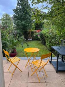 a yellow table and two chairs and a table at Appartement, piscine, Garches in Garches