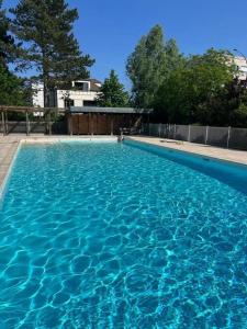 a large swimming pool with blue water at Appartement, piscine, Garches in Garches