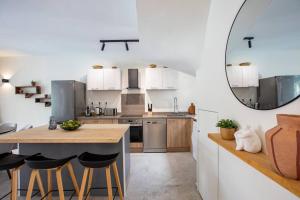 オリエントベイにあるSearulean, a stylish 3 bedroom abode in Orient Bayの白いキャビネットと大きな鏡付きのキッチン