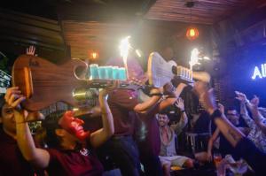 a group of people holding up their guitars in a party at Siesta Fiesta Hotel Adults Only - 5th Avenue in Playa del Carmen