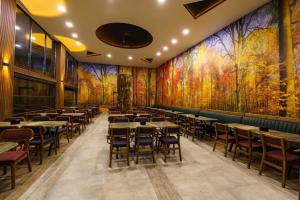 a restaurant with tables and chairs and colorful walls at Macartaşı Hotel in Macka