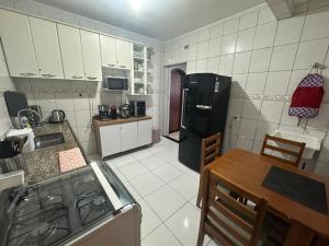 a kitchen with a black refrigerator and a table at Vista ao mar no Gonzaga in Santos