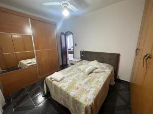 a bedroom with a bed and a dresser and a mirror at Vista ao mar no Gonzaga in Santos