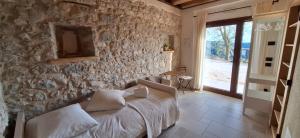 a bedroom with a stone wall with a bed and a window at Agriturismo La Pina in Tarzo +251 photos