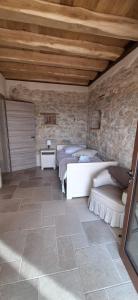 Agriturismo La Pina في Tarzo: غرفة نوم بسريرين وجدار حجري