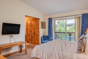 1 dormitorio con 1 cama, TV y ventana en Pine Ridge 05F, en Breckenridge
