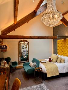um quarto com uma cama, uma cadeira e um espelho em Quite Simply French em Lancaster
