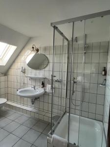 a bathroom with a glass shower and a sink at Hotel Fabritz in Essen