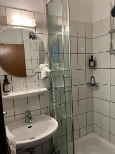 a bathroom with a sink and a shower at Hotel Fabritz in Essen