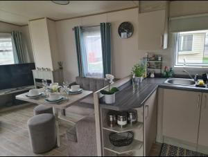 a kitchen with a table and a counter top at Delux Caravan - Clacton-on-sea in Jaywick Sands