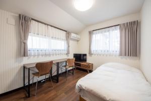 - une chambre avec un lit, un bureau et deux chaises dans l'établissement FAMILIA Kojiya - Vacation STAY 13467, à Tokyo