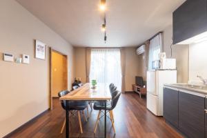 Il comprend une cuisine et une salle à manger avec une table et des chaises en bois. dans l'établissement FAMILIA Kojiya - Vacation STAY 13467, à Tokyo