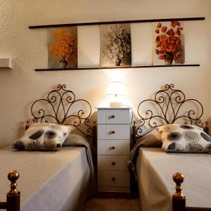 ein Schlafzimmer mit 2 Betten und eine Kommode mit einer Lampe in der Unterkunft B&B Villa Magnolia in Castel Giorgio