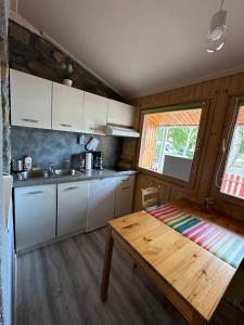 a kitchen with white cabinets and a wooden table at Andrea Apartman in Bük +16 photos