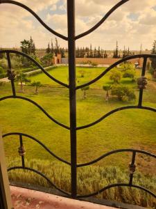 una ventana con vistas a un campo verde en Maison d’hôtes SOUIHLA en Oulad Sidi Cheïkh