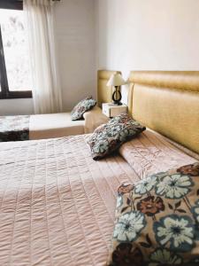 1 dormitorio con 2 camas y mesa con lámpara en Coronado Hotel en Mina Clavero