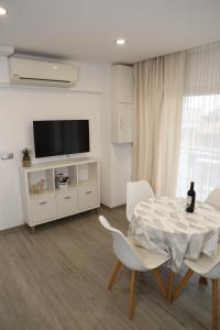 a living room with a table and chairs and a television at Apartamento el Cid in Calpe
