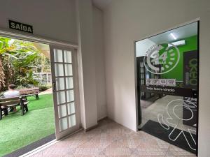 Una puerta a un edificio con un cartel. en Fabuloso flat 243 Amarílis 2 piscinas climatizadas, SKY 170 canais carregador veiculo elétrico Riviera de São Lourenço, Bertioga Apartamento Duplex inteiro, cozinha equipada completa, serviço de praia, limpeza e trocas diária de toalhas, wi-fi 500mb, en Riviera de São Lourenço