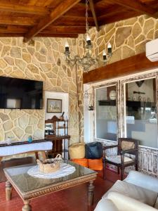 sala de estar con mesa y pared de piedra en Casa Chiozza en San Bernardo