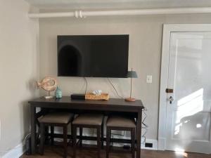 Una mesa de comedor con sillas y un televisor en la pared. en Annapolis @Gate 1 steps to the Harbor Free parking, en Annapolis