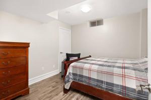 a bedroom with a bed and a wooden dresser at Walk-out Basement with Private Entrance in Brampton