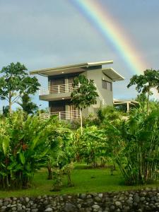 un arcobaleno di fronte a una casa con di The Fruit Tree Garden Bromeliad Suite a Nuevo Arenal