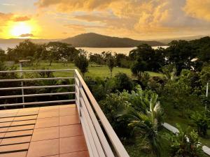 - un balcon avec vue sur l'océan au coucher du soleil dans l'établissement The Fruit Tree Garden Bromeliad Suite, à Nuevo Arenal