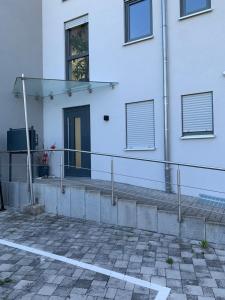 ein weißes Gebäude mit einem Balkon und einer Tür in der Unterkunft Ferienwohnung Gergert Nr6 in Löwenstein