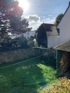 een achtertuin met een stenen muur en een tuin bij Chic et cosy maison année 30 in Lorient