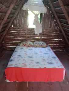 Bett in einem Zimmer in einem Holzhaus in der Unterkunft Cabana juriti in Camaçari