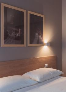 1 dormitorio con 1 cama con 2 cuadros en la pared en Agriturismo Querceto, en Frazione Mocaiana