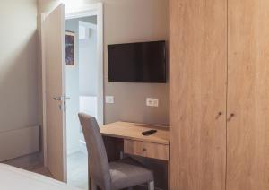 1 dormitorio con escritorio y TV en la pared en Agriturismo Querceto en Frazione Mocaiana