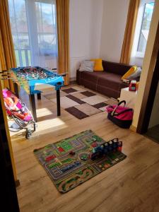 een woonkamer met een tafel en een speelgoedtrein op een tapijt bij Dom na Ubocy in Groń