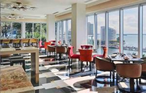 a restaurant with tables and chairs and windows at LUXURY 1BR CONDO W Icon Brickell-FREESPA in Miami