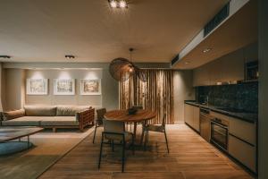 eine Küche und ein Wohnzimmer mit einem Tisch und einem Sofa in der Unterkunft Get Hotel Molvento, AKEN Soul Collection in Villa General Belgrano