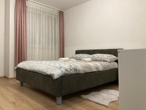 um quarto com uma cama num quarto com uma janela em Apartman Palac em Grude